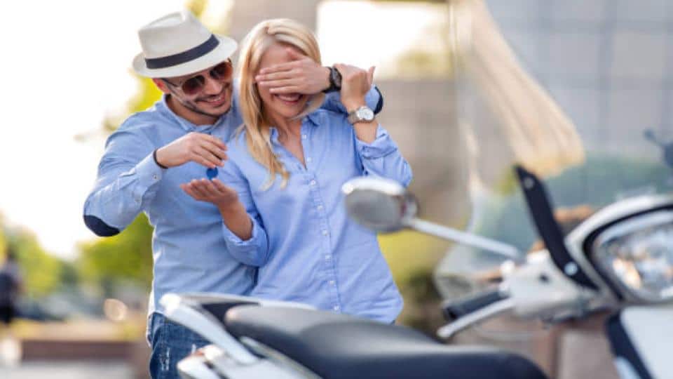 man handing a motorcycle key to a woman