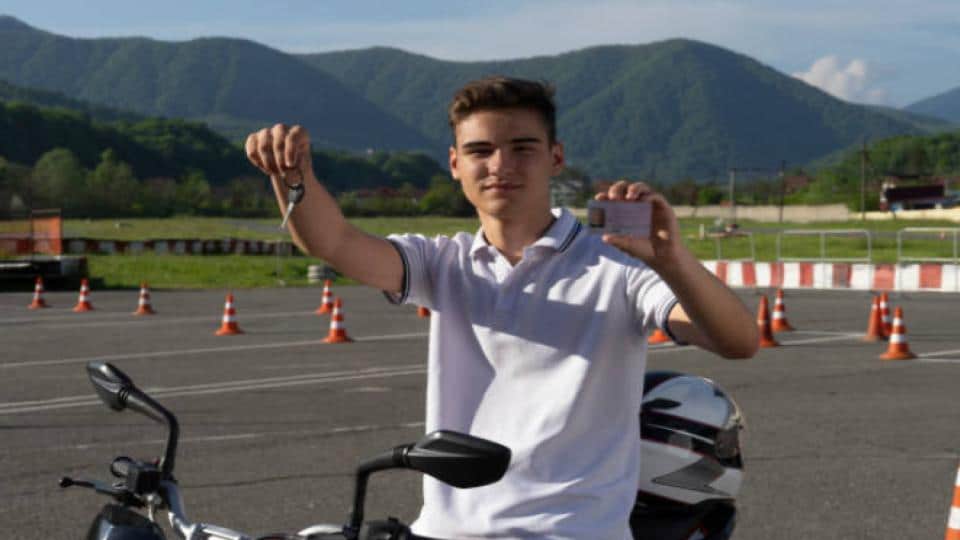 teen holding a driver's license and motorcycle key