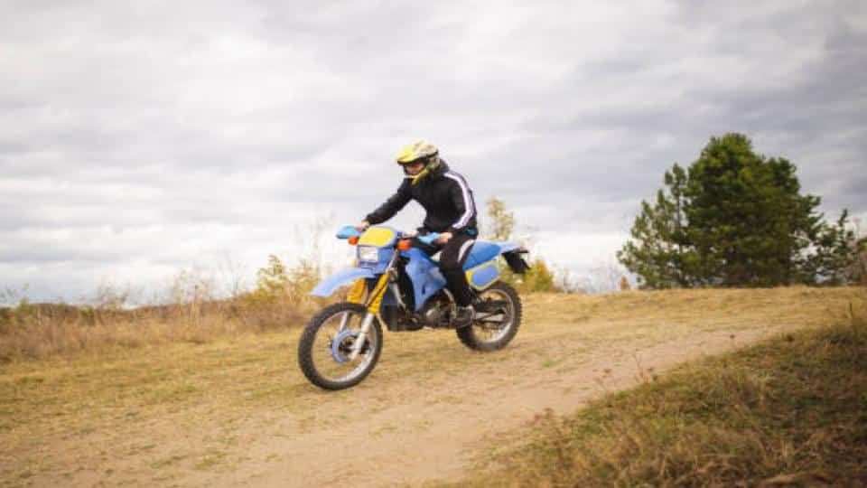 man riding a dirt bike on rough road