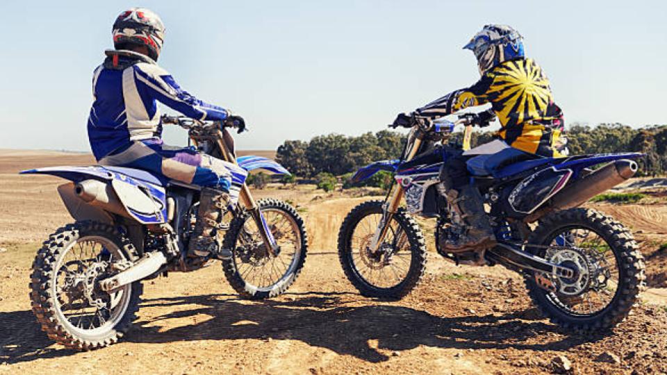 two dirt bike riders on rough road